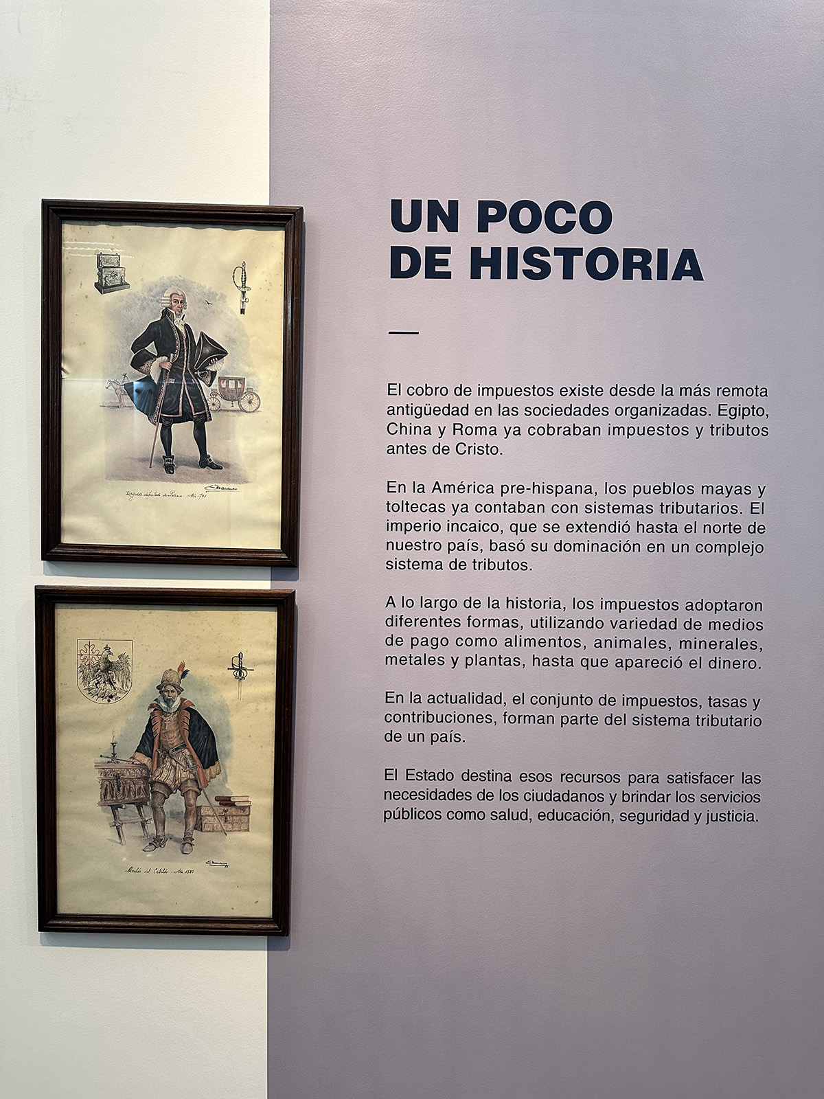 Foto de una pared del museo con dos cuadros con dibujos de personas y un texto que empieza con el título “UN POCO DE HISTORIA”
